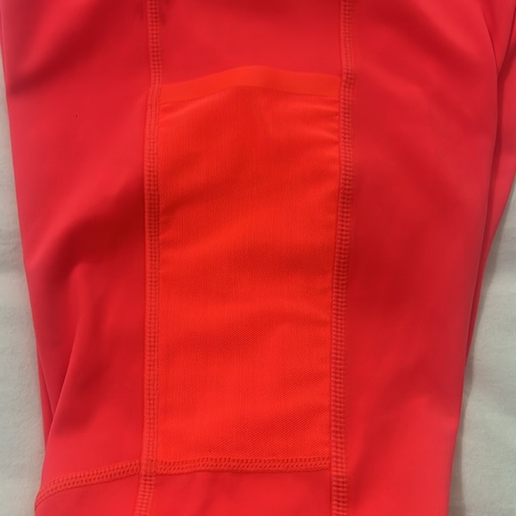 Fabletics bright orange leggings with zipper at the ankle and side pockets. - Picture 3 of 4